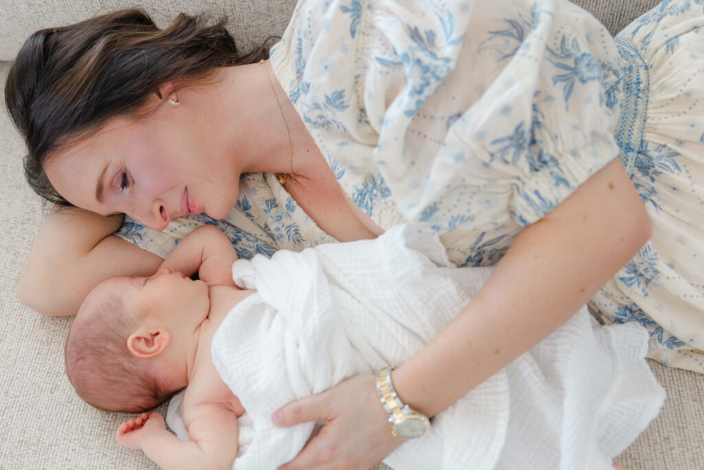 Mother and newborn baby lying together during an in-home session in Fort Collins