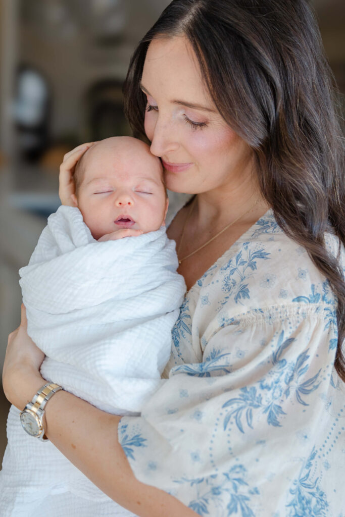 Mom snuggling newborn baby wrapped in soft blanket during a Northern Colorado lifestyle session